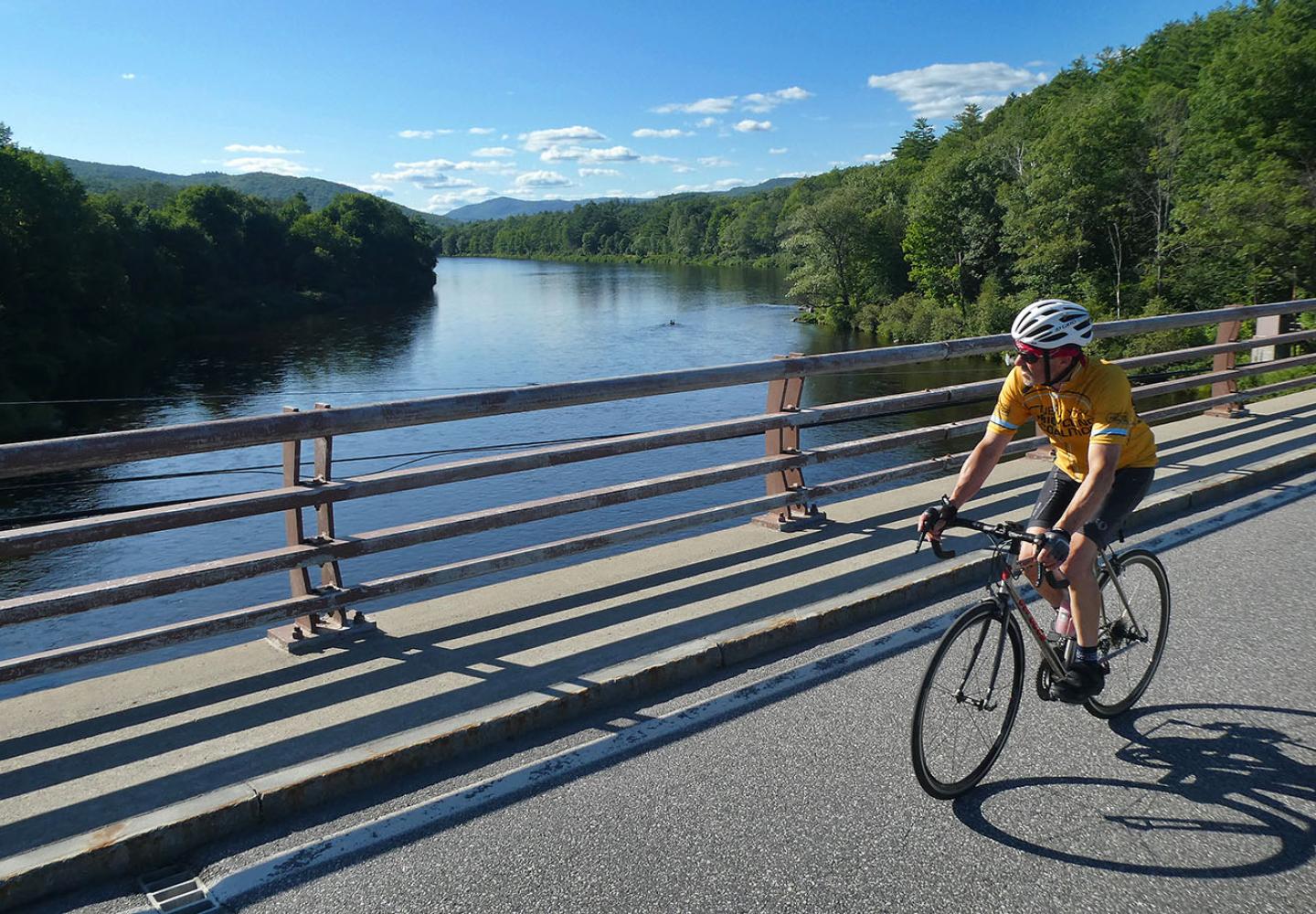 A cyclist enjoys the view of the Hudson River while riding near North Creek.