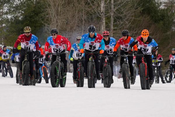 The first wave of riders leaves the starting line during the 2023 Empire State Winter Games Winter Bike races held at Dewey Mountain Recreation Center in Saranac Lake.