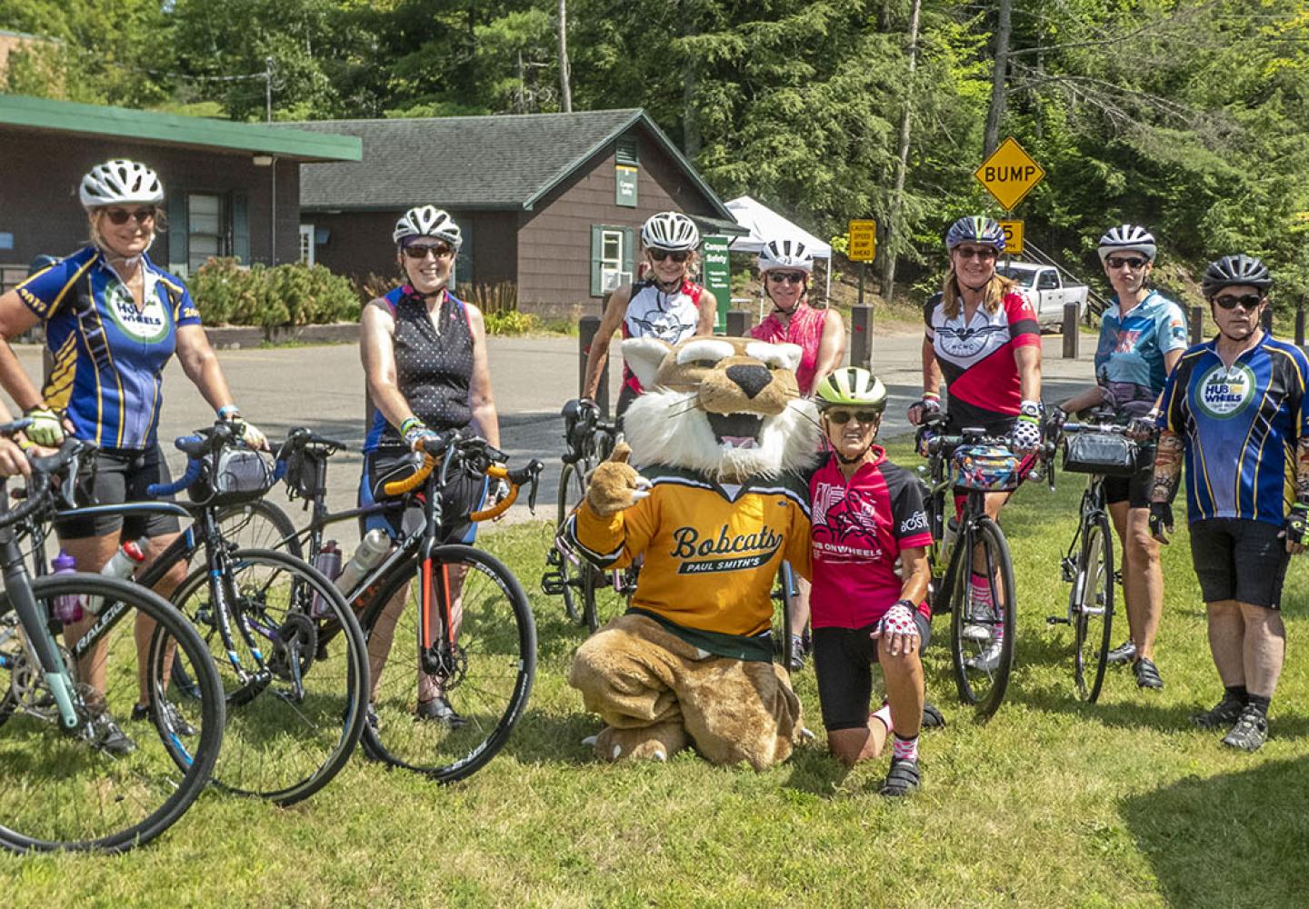Members of the Worchester County Women's Cycling club pose for a picture with the Paul Smith's College bobcat before heading out on a ride.