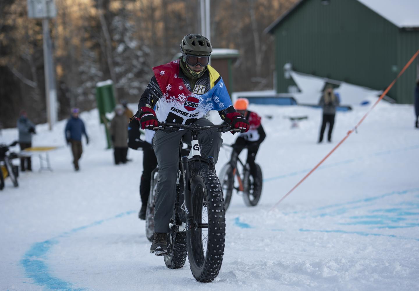 Bicyclists round a corner during the Empire State Winter Games Cross-Country Biking 5K race at Mt Pisgah on Saturday, February 5, 2022. (Photo by Kayla Breen/Newhouse School)