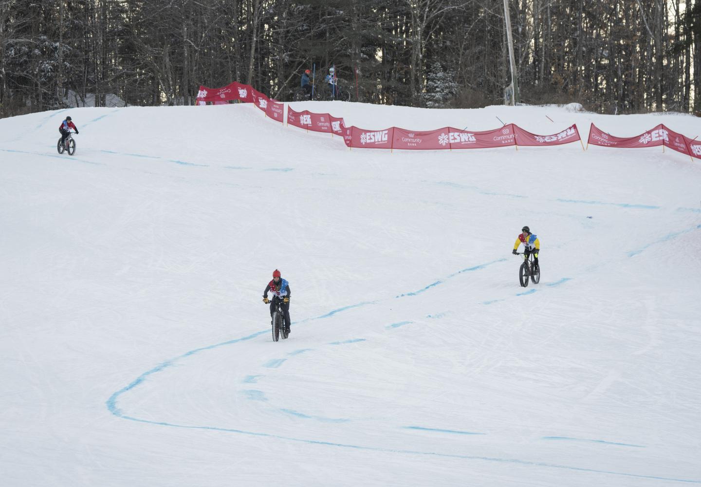 Bicyclists round corners through the downhill portion of the course during the Empire State Winter Games Cross-Country Biking 5K race at Mt. Pisgah on Saturday, February 5, 2022. (Photo by Kayla Breen/Newhouse School)