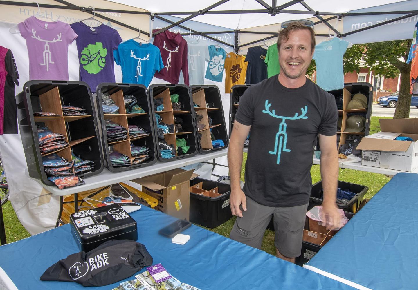 BikeADK owner Doug Haney works the merch tent at the Saranac Lake Farmer's Market.