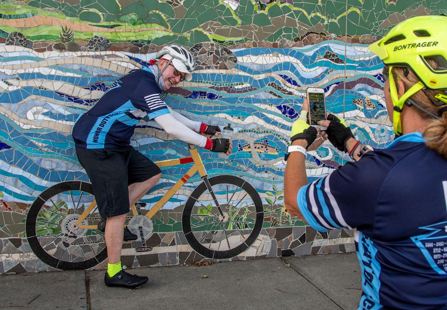 Cyclists take a photo at the North Creek Mosaic Project.