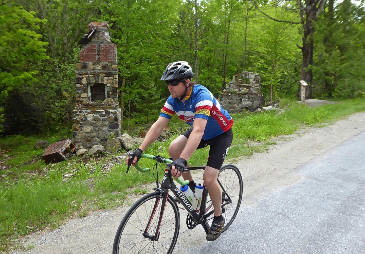 A cyclist pedals past remnants of a mining town in Tahawus