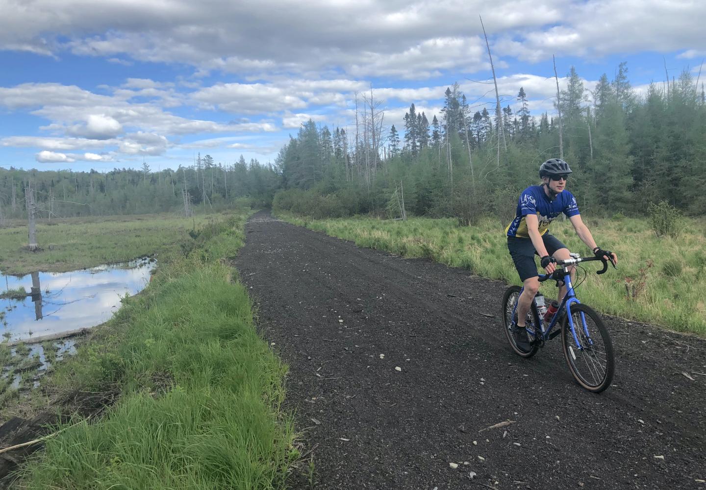 A cyclist rides the Adirondack Rail Trail corridor west of Saranac Lake. Photo by Phil Brown