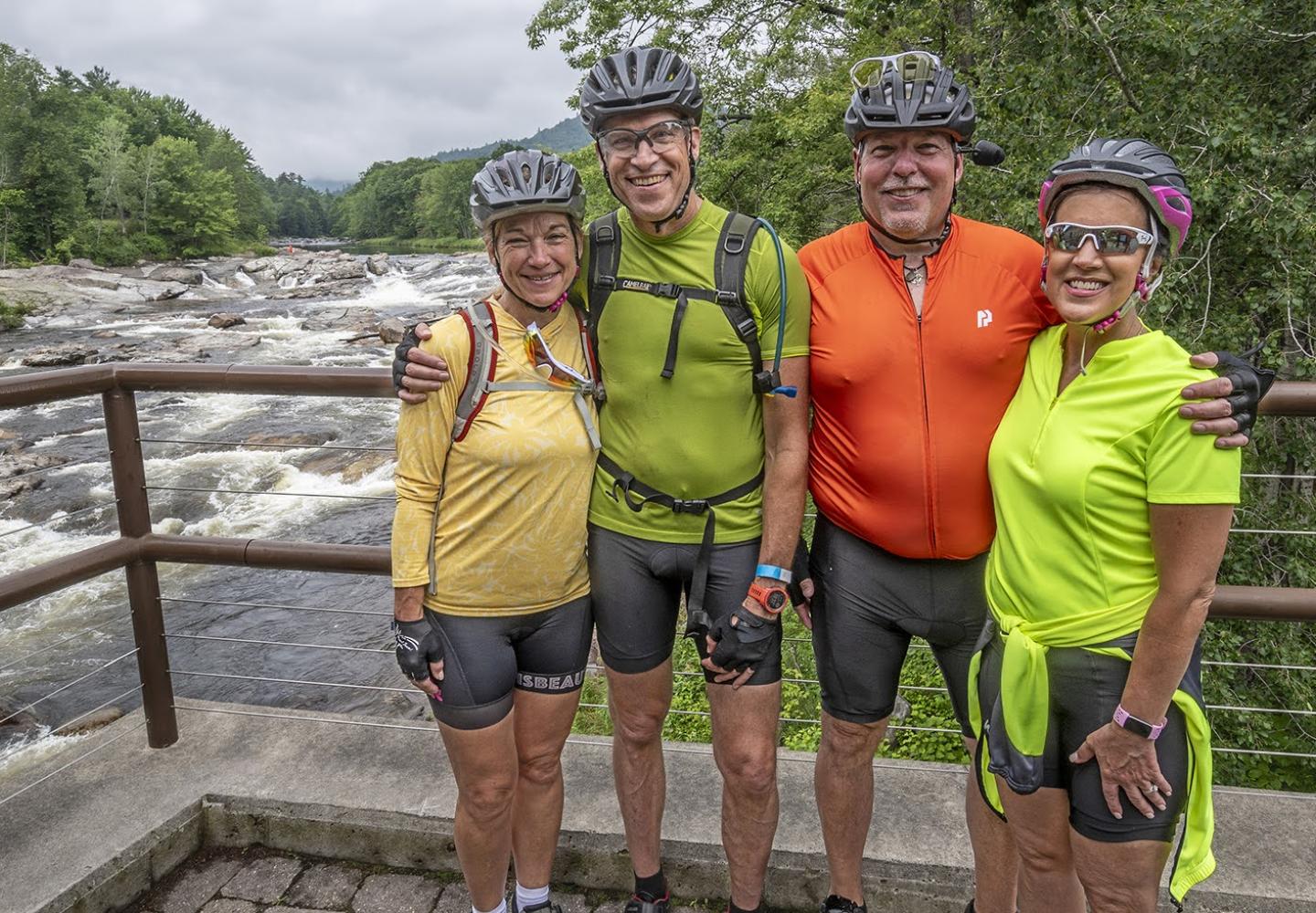 A group of Ride for the River cyclists enjoy the view at the Historic Jay Covered Bridge.