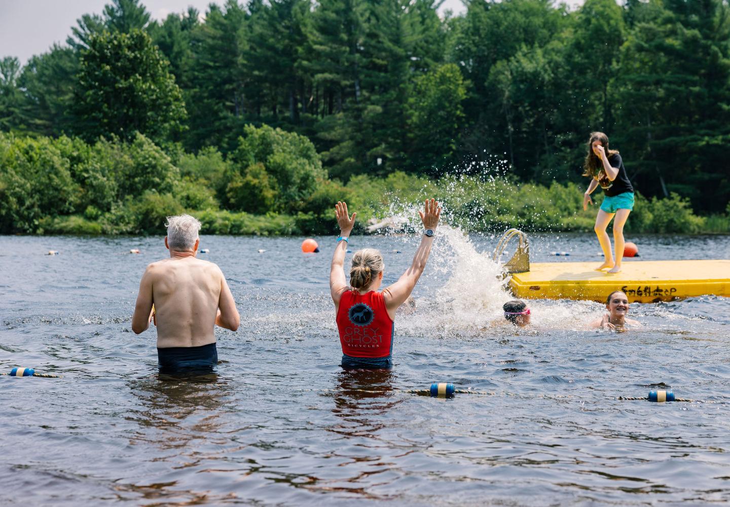 Cyclists splash in the Ausable River after enjoying Ride for the River supporting Ausable Freshwater Center