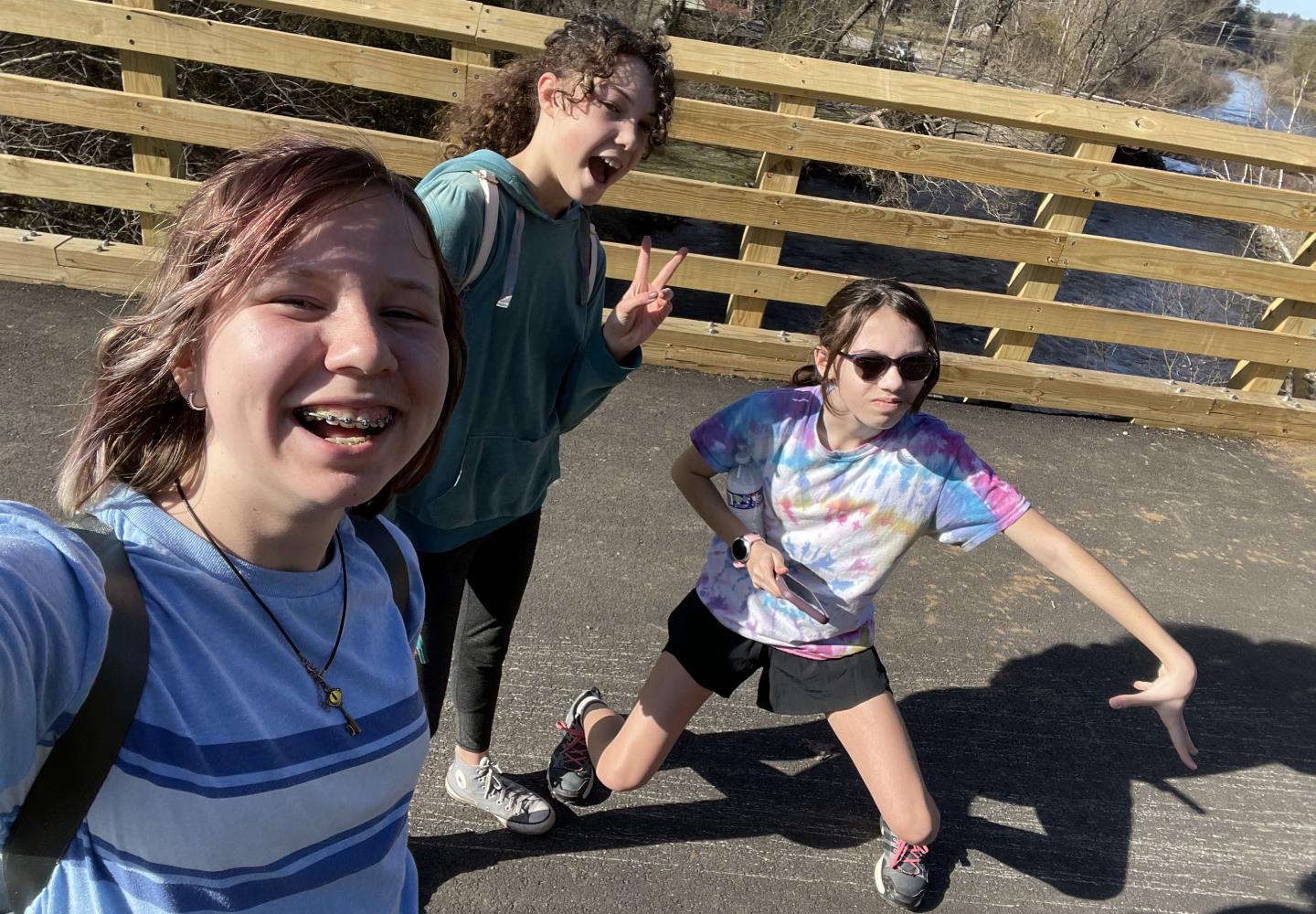 A group of kids take a selfie while walking through Saranac Lake on the Adirondack Rail Trail.