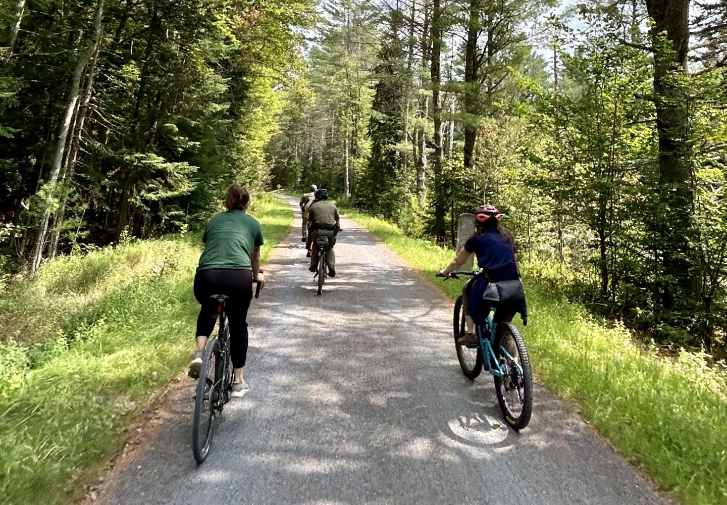 Bicyclists pedal along Lake Clear during a ride on the Adirondack Rail Trail.