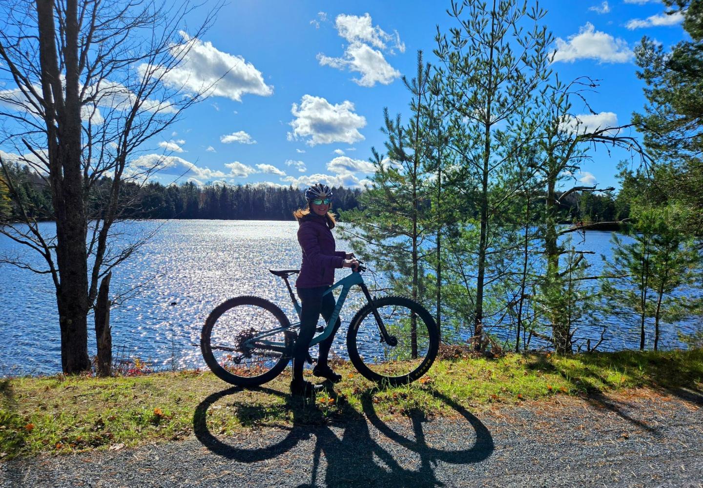 A bicyclist enjoys the stunning water views along the Adirondack Rail Trail.