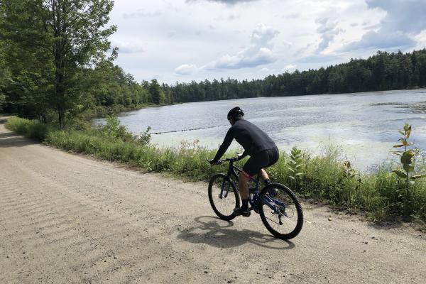 A cyclist passes middle pond on Floodwood Road. 